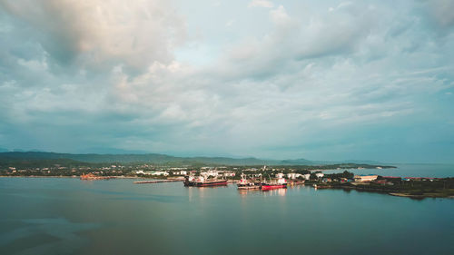 Aerial view of townscape by sea against sky