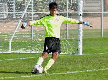 Young man playing soccer on field