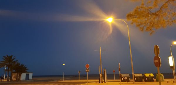 View of illuminated street lights against sky during sunset