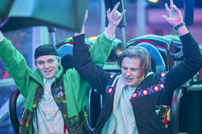 Friends enjoying at amusement park during night