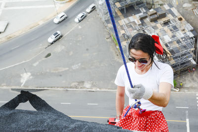 Caucasian woman wearing hero costume descending a tall building in rappel. salvador bahia brazil.