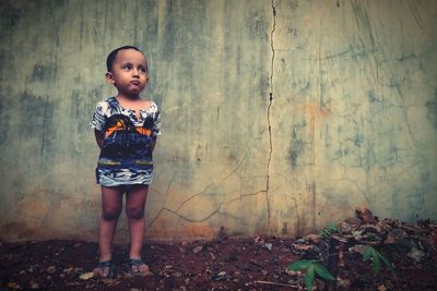 Cute boy looking away while standing outdoors