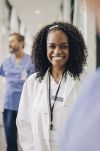 Portrait of smiling female physician with curly hair at hospital