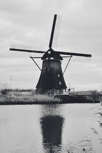 Traditional windmill on landscape against sky