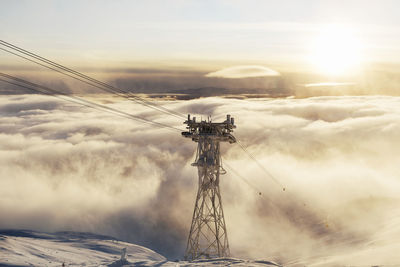 Ski lift tower above clouds