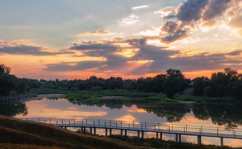 Bridge over river against sky during sunset