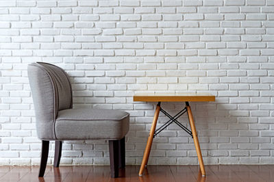 Empty chair by table against wall at home