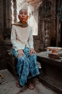 Portrait of woman standing against wall