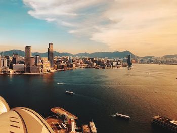 Scenic view of sea and buildings against sky during sunset