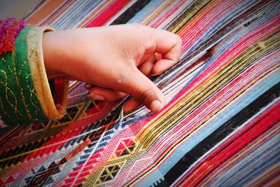 Cropped hand of woman with fabric on loom