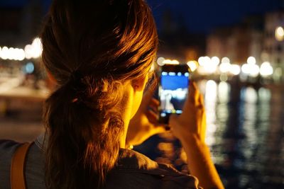 Woman in illuminated city at night
