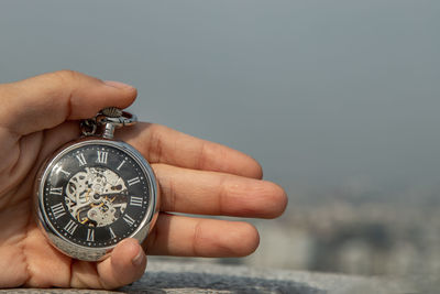 Close-up of hand holding clock