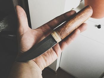 Close-up of hand holding knife in kitchen