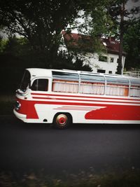 Red vintage car on road in city