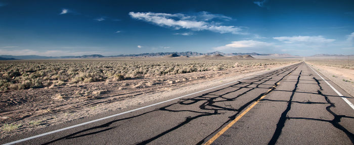 Tire tracks on landscape against sky