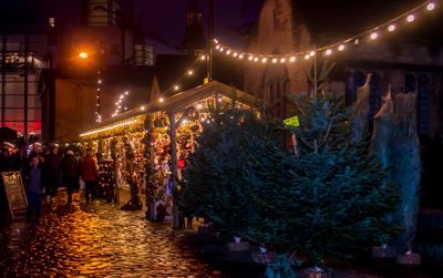 Illuminated street market in city at night