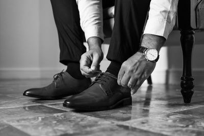 Low section of man standing on hardwood floor