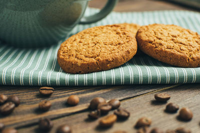 High angle view of cookies by drink in cup and beans on table