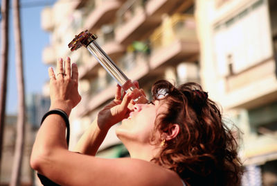 Portrait of woman holding camera in city