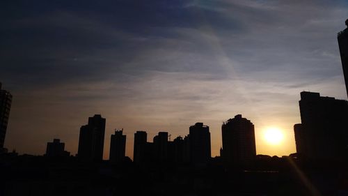 Silhouette buildings against sky during sunset