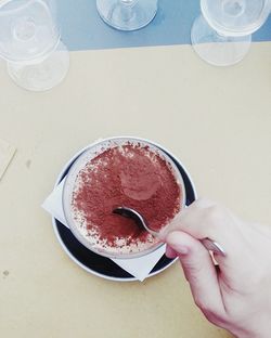 High angle view of woman holding coffee cup on table