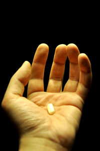 Close-up of human hand against black background