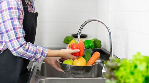Midsection of man preparing food in kitchen at home