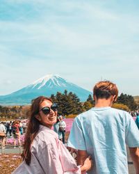 Portrait of friends on mountain against sky