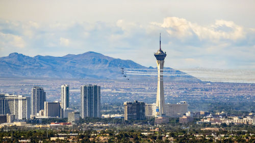 Modern buildings in city against cloudy sky