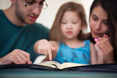 Close-up of mother and woman reading book