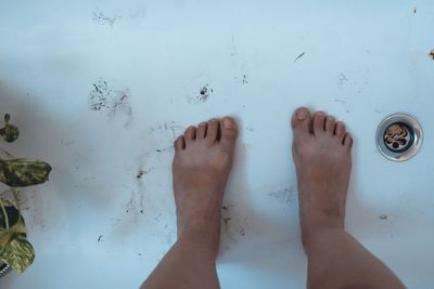 Low section of person standing on wet floor