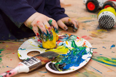Midsection of man painting on table