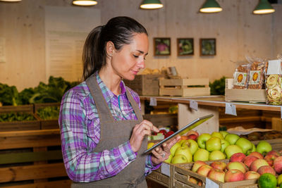 Smiling businesswoman using digital tablet at fruit store