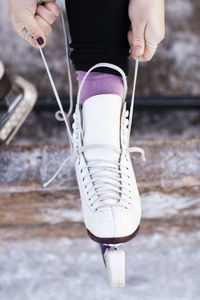 Woman putting ice skate on