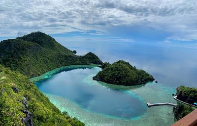 Scenic view of sea and mountains against cloudy sky