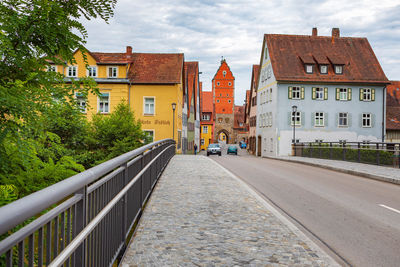 Road amidst buildings against sky