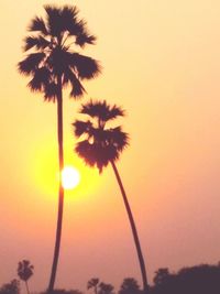 Low angle view of silhouette palm trees against romantic sky