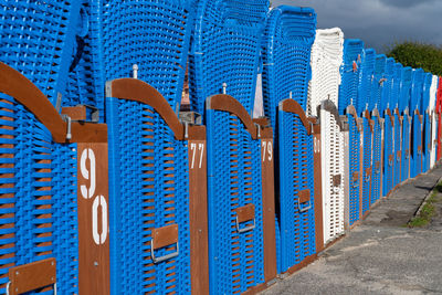 Row of multi colored fence against blue sky