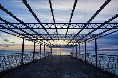 Bridge over sea against sky during sunset
