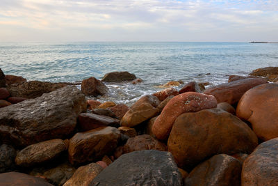 Rocks on beach against sky