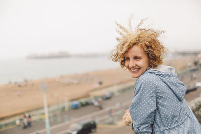 Happy woman at brighton pier against clear sky