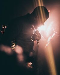 Full length of man holding illuminated light at night