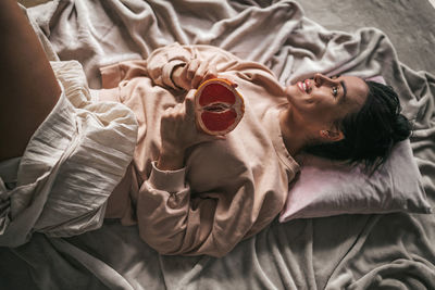 High angle view of woman lying on bed