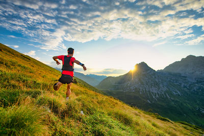 Rear view of man on mountain against sky