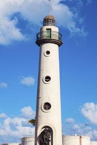 Lighthouse by sea against sky