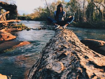 Rear view of man sitting on rock