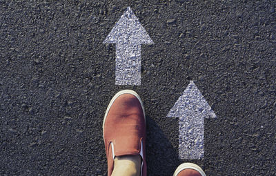 Low section of man standing on road