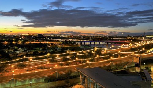 High angle view of illuminated cityscape against sky at sunset