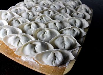 High angle view of dumplings on cutting board over black background