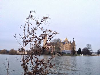 Built structure by river against clear sky